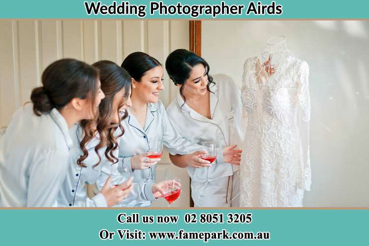 Photo of the Bride and the bridesmaids looking at the wedding gown Airds NSW 2560