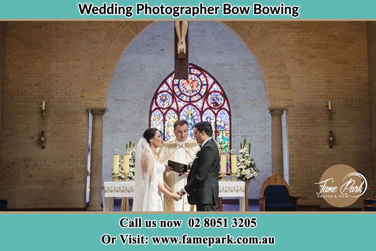 Photo of the Bride and Groom at the Altar with the Priest Bow Bowing NSW 2556