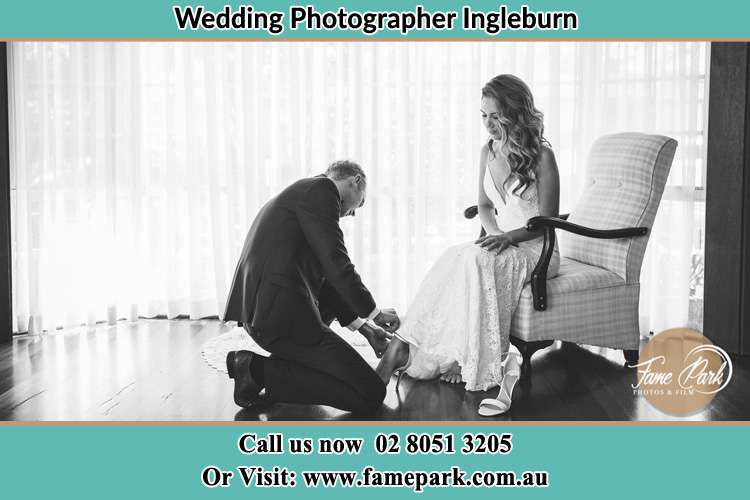 The Bride is being helped by the Groom trying to put on her shoes Ingleburn NSW 2565