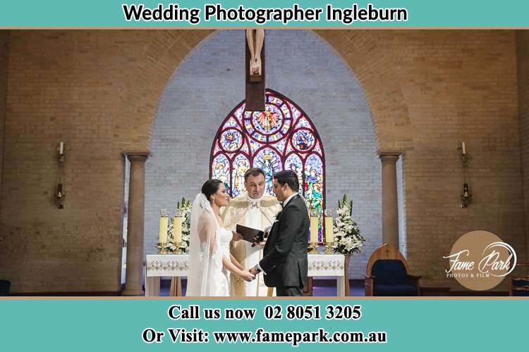 Photo of the Bride and Groom at the Altar with the Priest Ingleburn NSW 2565