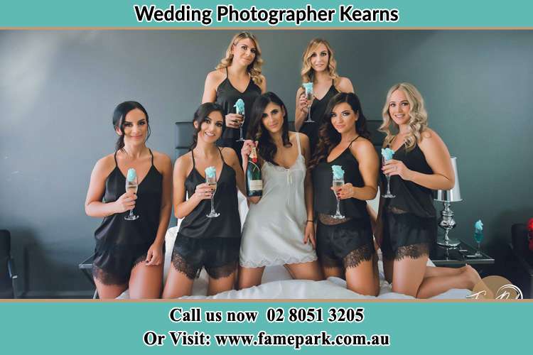 Photo of the Bride and the bridesmaids wearing lingerie and holding glass of wine on bed Kearns NSW 2558