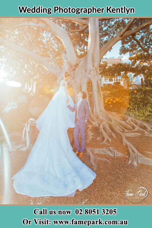 Photo of the Bride and the Groom looking each other besides the tree Kentlyn NSW 2560