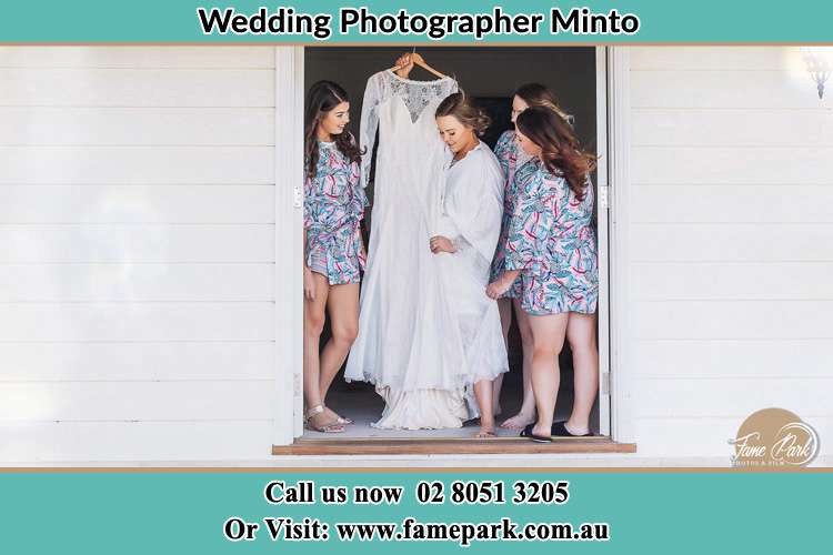 Photo of the Bride and the bridesmaids checking the wedding gown at the front door Minto NSW 2566